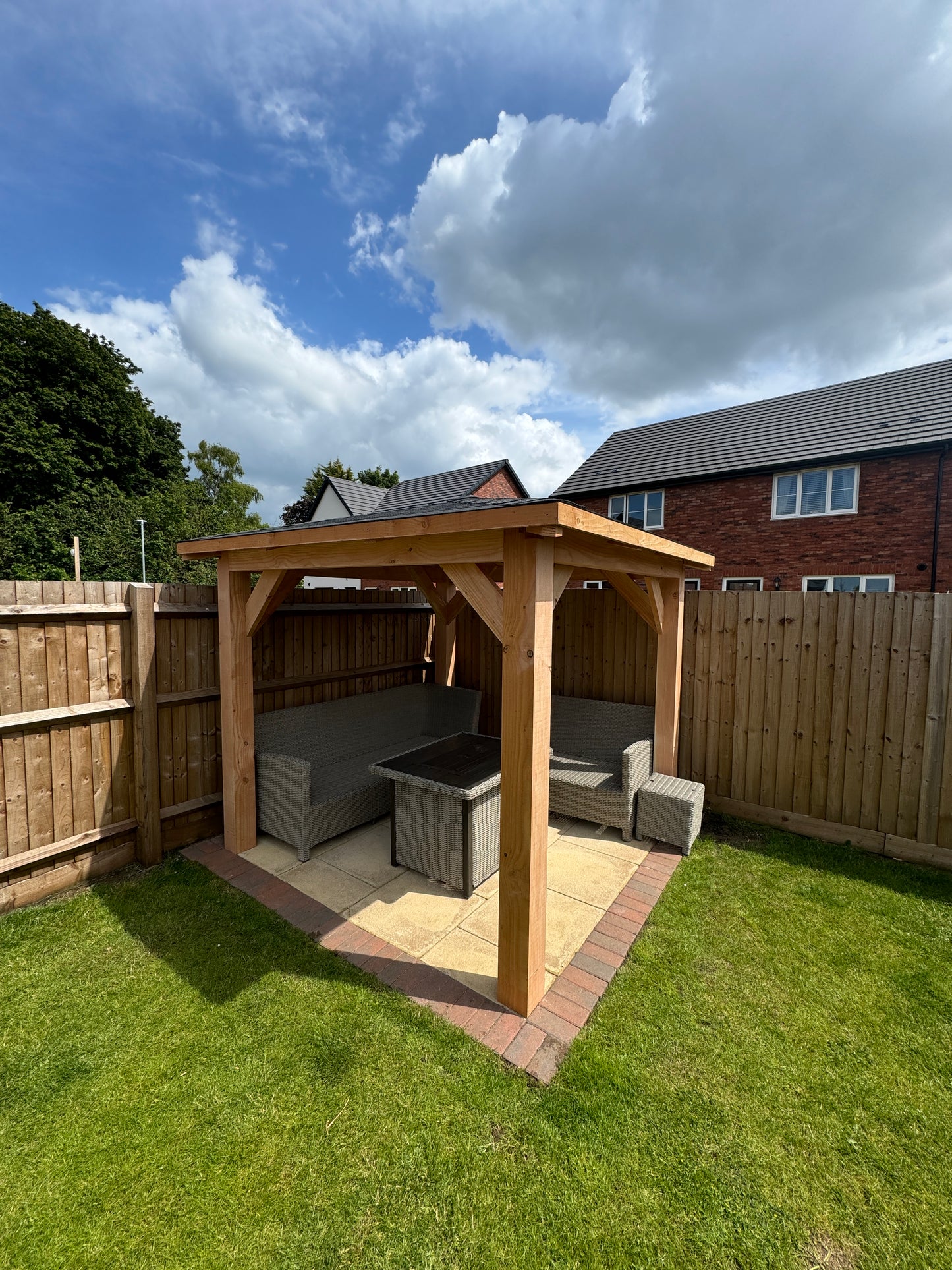 Wooden gazebo on a patio with furniture underneath