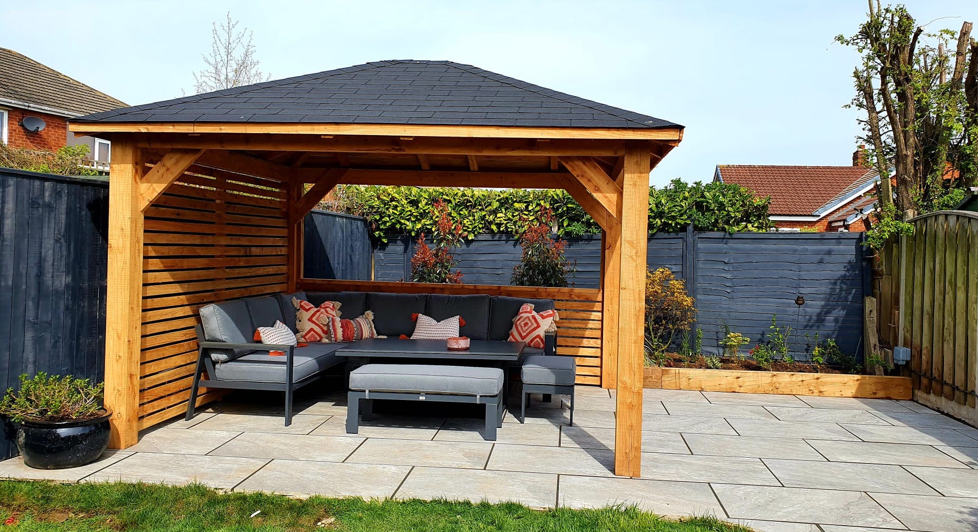 3.5m square larch timber gazebo with hit and miss cladding and black felt shingles. 