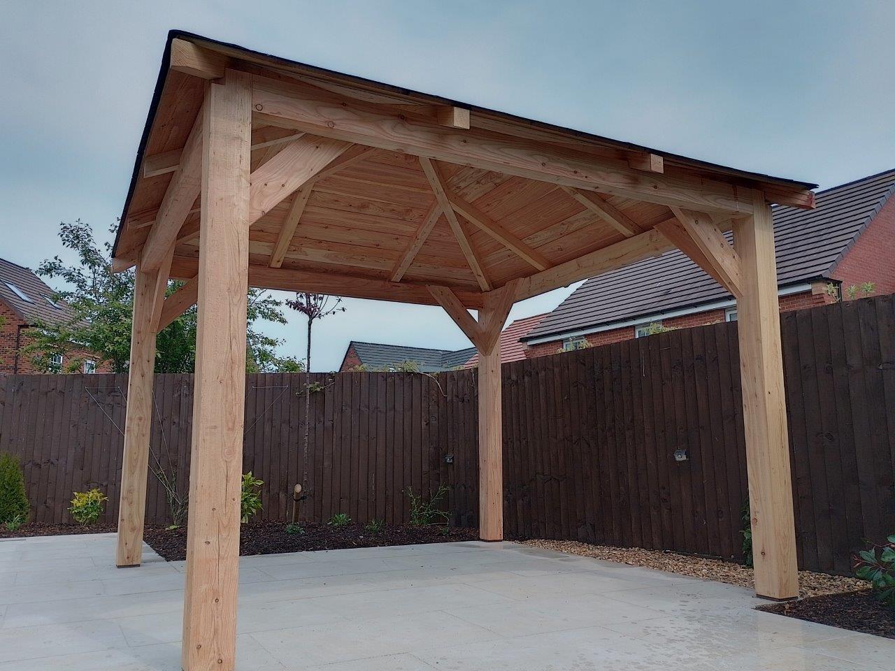 3m square larch wooden gazebo in a garden on a patio