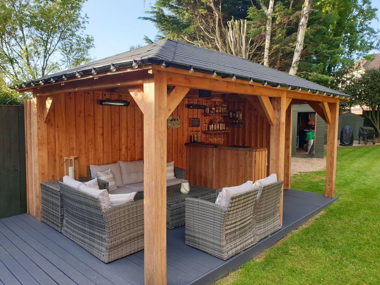 6m X 3m Larch wooden gazebo with boar and batten cladding for a outdoor bar and eating area