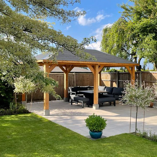 Large chunky timber gazebo with 6 post in a garden on  a patio