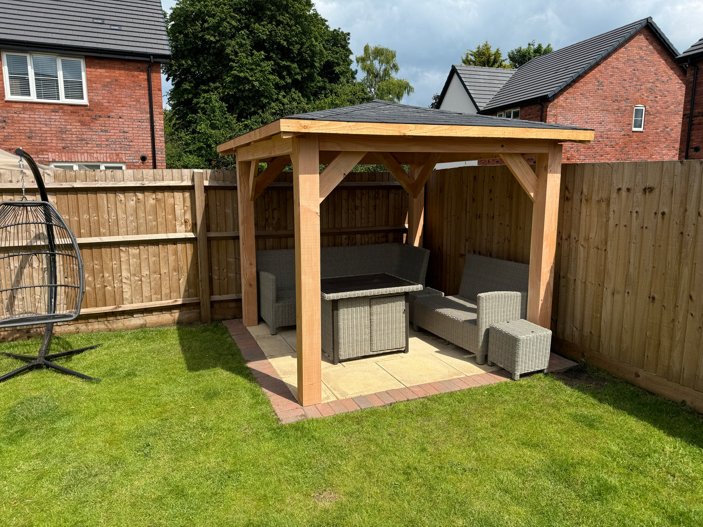 imber gazebo on a grassy lawn with a house in the background
