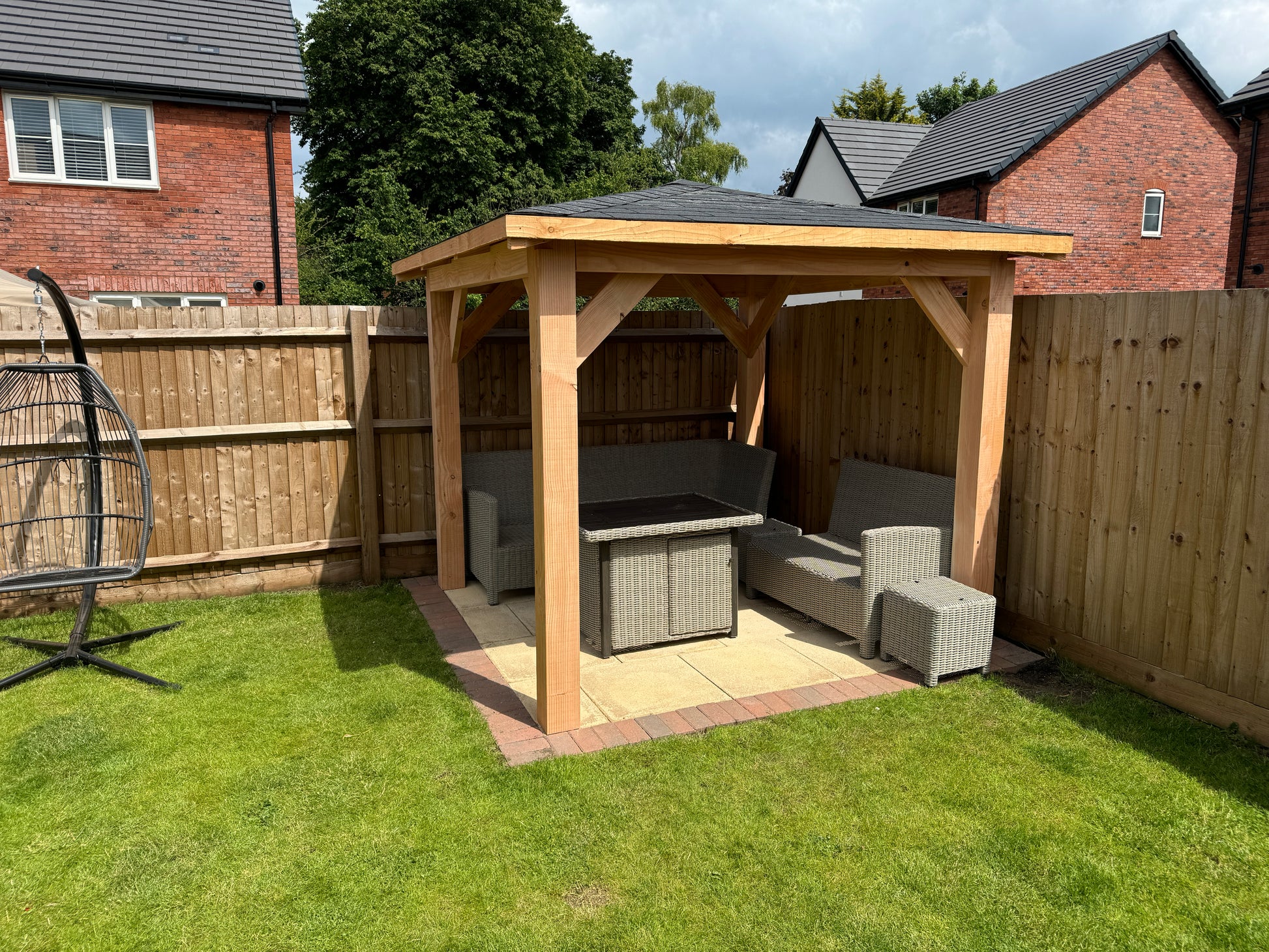 imber gazebo on a grassy lawn with a house in the background